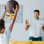 selective focus of happy father looking at son with basketball